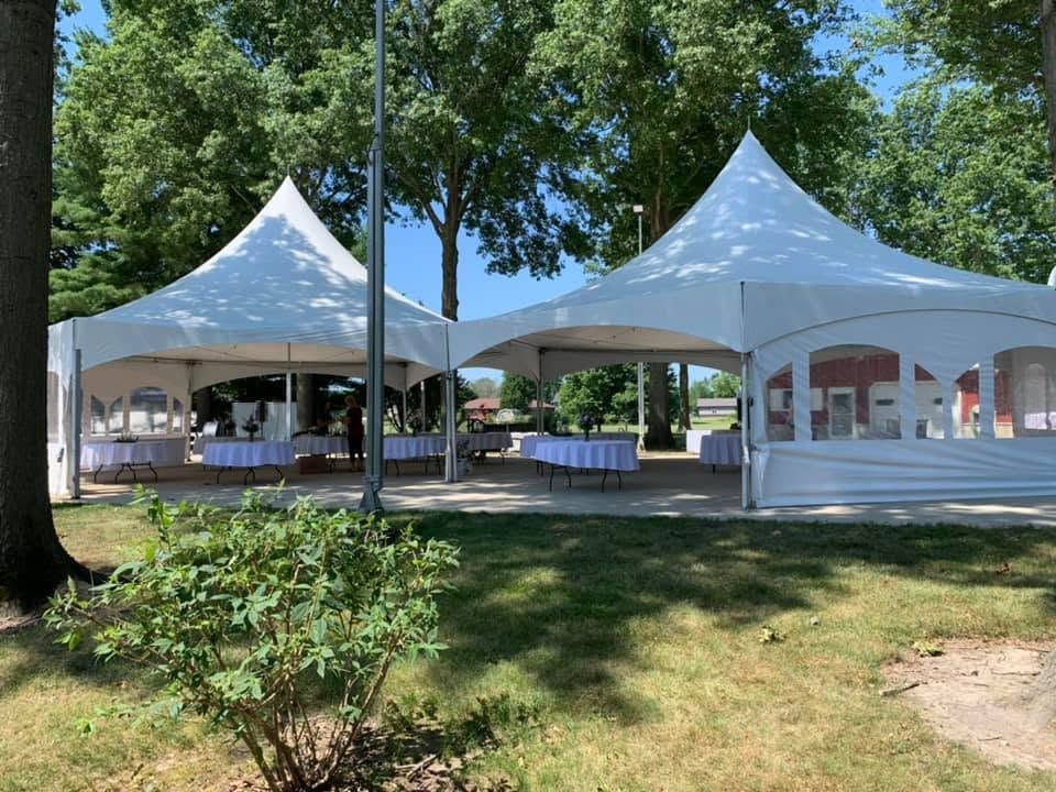 Two high-peak tents with round tables and linens