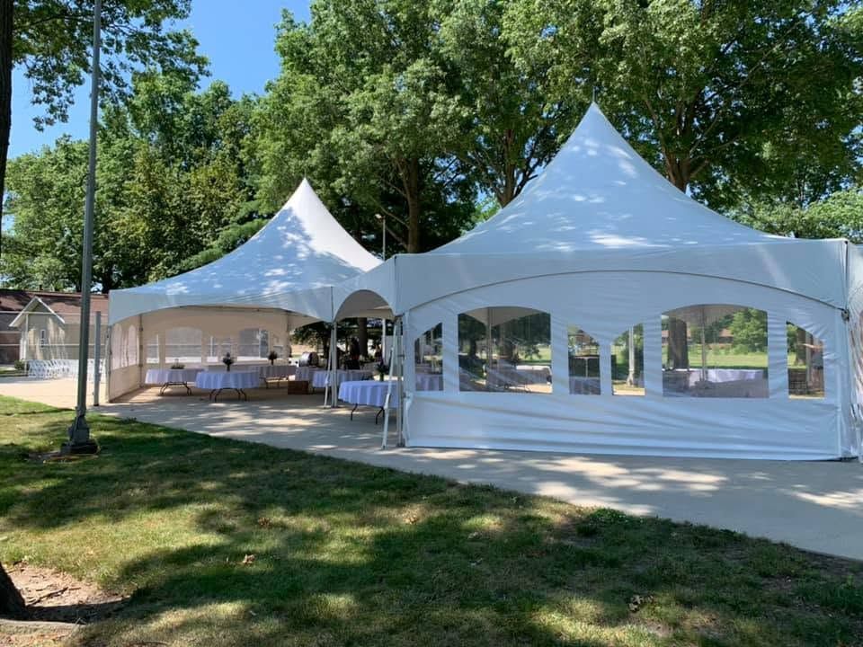 White high-peak tents with window sidewalls over round tables